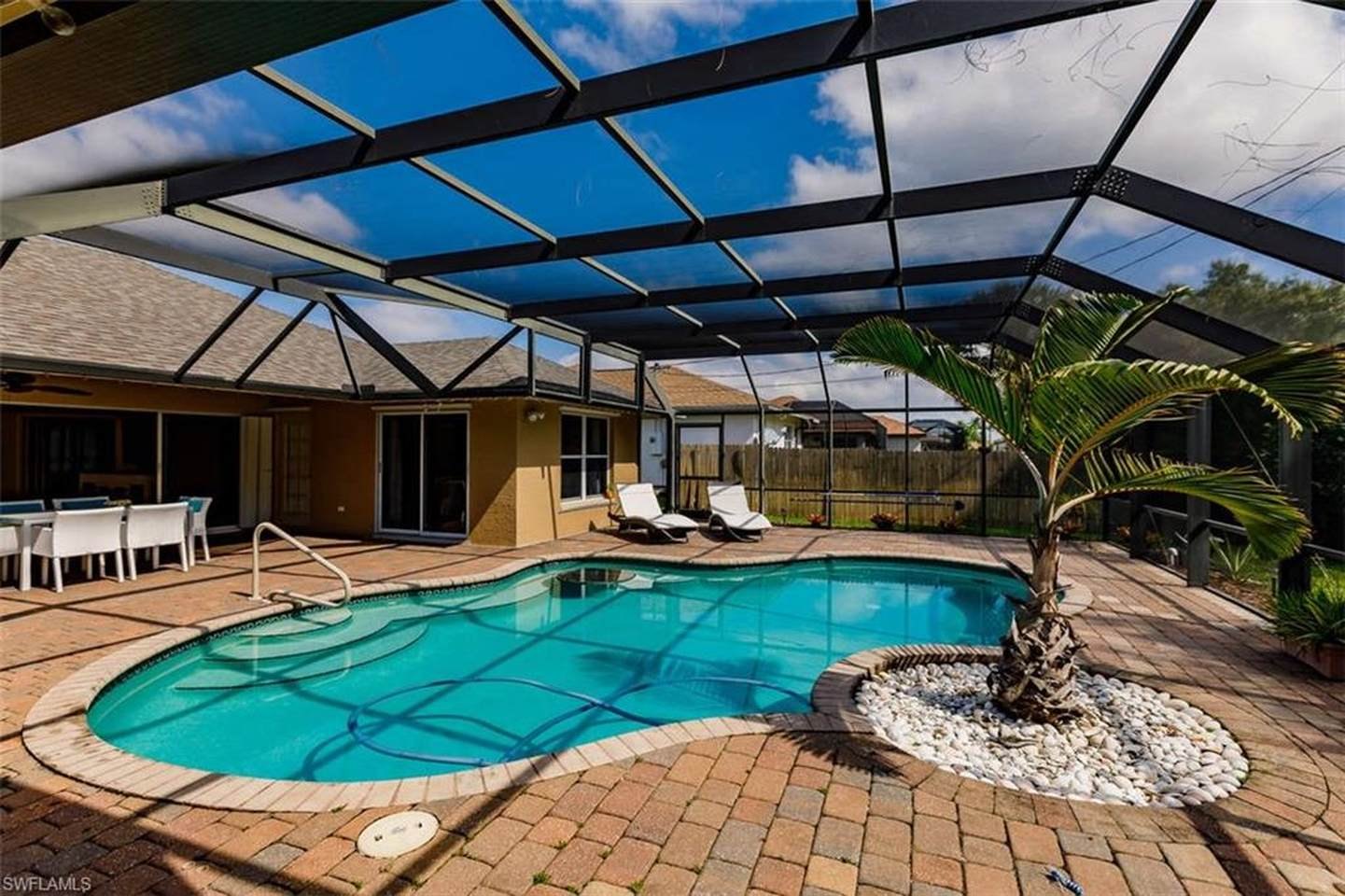 Screened resort-style pool area at Tiki Paradise Retreat